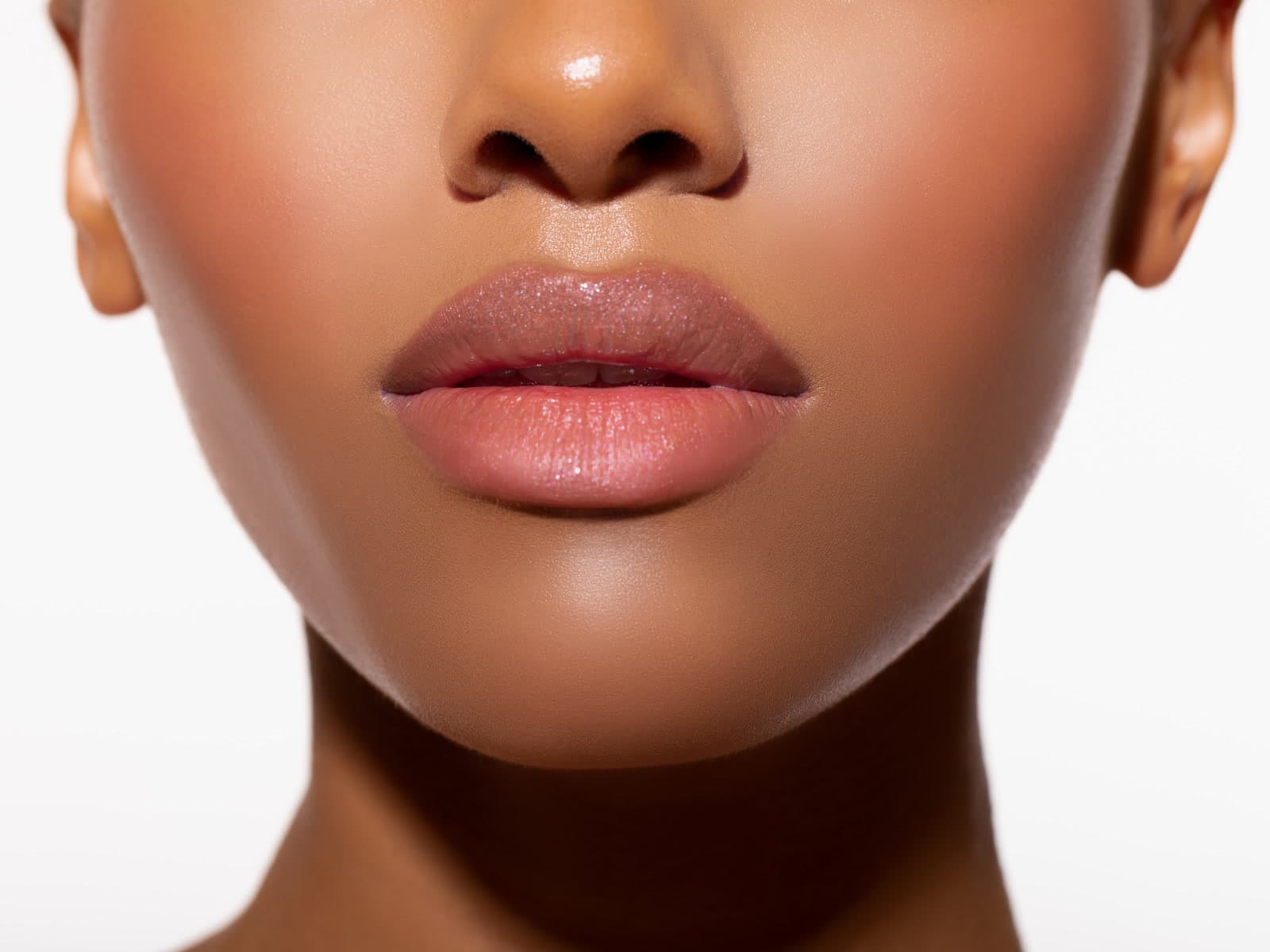 A close view of a woman's mouth and chin, lips softly highlighted