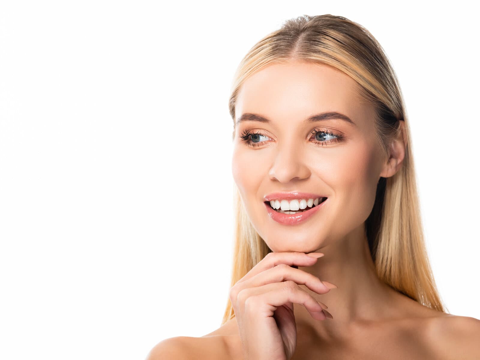 A woman smiling and looking off-camera against a white ground, one hand at her chin