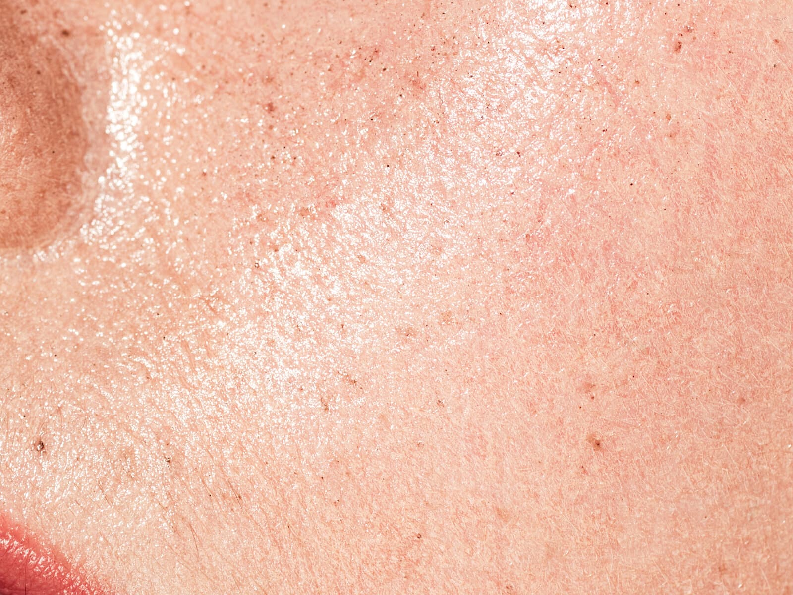 A macro view of the skin of a woman's cheek, pores and fine texture visible