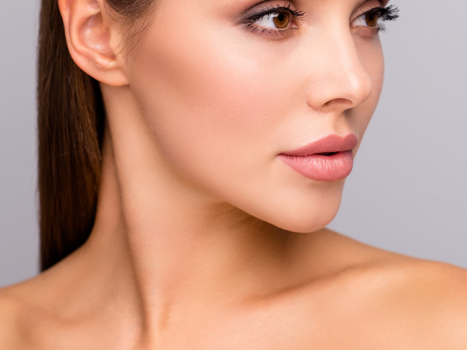A woman's face in three-quarter profile, showing the line of the jaw and neck